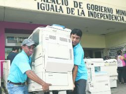 Trabajadores de la alcaldía de Iguala sacaron máquinas de oficina y documentos ante una inminente irrupción de los manifestantes. AFP /