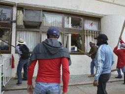 Manifestantes rompen ventanas del palacio municipal en la ciudad de Iguala. AP / A. González