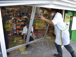 Empleados de las tiendas saqueadas resguardan los establecimientos a la espera de acción de las autoridades. AFP / Y. Cortez