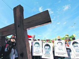 Colocan ofrenda. Familiares de los jóvenes celebraron una misa en honor a los 43 desaparecidos en Iguala. EFE /