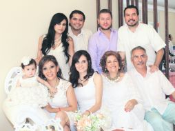 La festejada en brazos de su madre y en compañía de familiares.  /