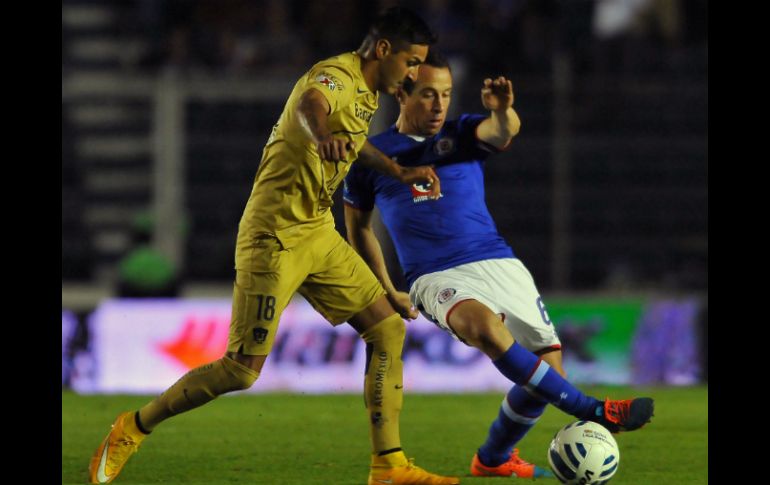 El jugador de Pumas, Ismael Sosa (i) compite por el balón con Gerarardo Torrado del Cruz Azul durante el partido en el estadio Azul. AFP / M. Calls