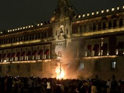 Miles de manifestantes marcharon ayer hasta el Zócalo capitalino. Un grupo reducido prendió fuego a la puerta de Palacio Nacional. AFP / O. Torres