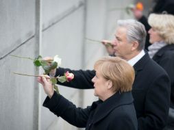 Angela Merkel coloca una flor en el muro simbólico del sitio que conmemora los hechos de 1989. AP / M. Schreiber