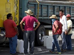 Manifestantes sacan combustible de un camión en la autopista de México a Acapulco. AFP / R. Schemidt