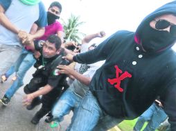 Descargan su ira. Antes de llegar al Aeropuerto, estudiantes se enfrentaron con policías de Acapulco que les impedían el paso. AFP /