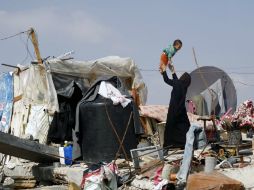 Una mujer palestina sobre los escombros de la casa de su familia que fue destruida durante la guerra de Gaza. AFP / M. Abed