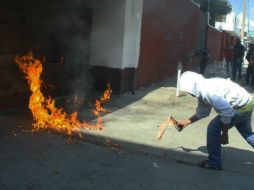 Un joven intenta incendiar la puerta de las instalaciones del PRI en Oaxaca. EFE /