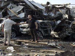 Personas observan los destrozos causados por la explosión de un coche bomba en Bagdad. EFE /