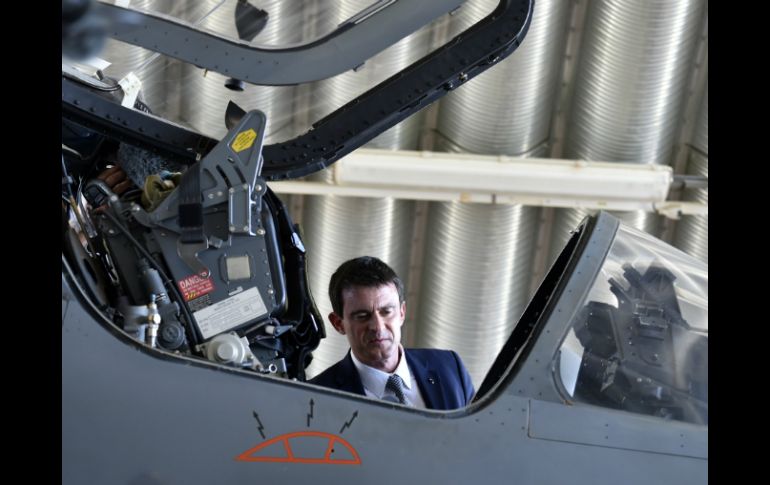 El primer ministro francés, Manuel Valls observa el interior de un Mirage 2000-D. AFP / M. Medina