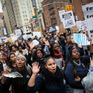 Marchan con las manos alzadas en memoria de Michael Brown