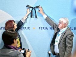 Marisol Schulz sostiene el moño negro en el muro de uno de los salones de conferencias de la FIL. EL INFORMADOR / E. Barrera