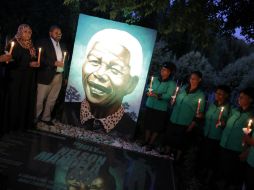 Varias personas participan en un acto conmemorativo a un año de la muerte de Nelson Mandela. EFE / K. Ludbrook