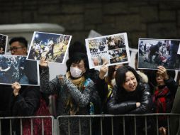 Manifestantes muestran imágenes de encuentros entre la policía y pro democráticos, durante protesta contra la brutalidad policiaca. AFP / I. Lawrence
