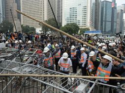 Los trabajadores siguen retirando barricadas en una de las vías principales de la zona de protestas. AFP / D. De la Rey