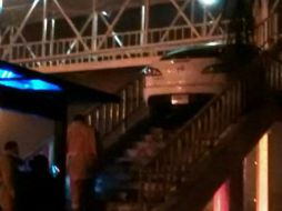 El vehículo, un Mazda blanco, quedó sobre las escaleras del puente; según autoridades, el conductor escapó de la escena. ESPECIAL /