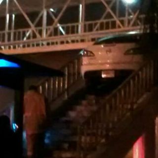 Automóvil sube por escalera de puente peatonal