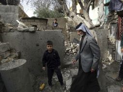 Un grupo de personas inspeccionan su casa dañada tras un ataque en la ciudad chiíta de Karbala. AP / H. Mizban