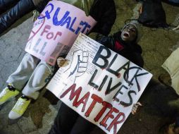 Manifestantes sostienen pancartas con mensajes en contra del sistema. AFP / K. Betancur
