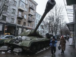 Viandantes pasan junto a un tanque IS-3 de la era soviética, usado por rebeldes prorusos contra el ejército ucraniano. EFE / R. Pilipey