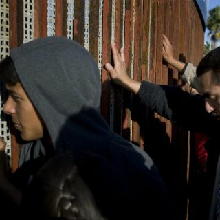 Migrantes 'piden posada' en muro fronterizo