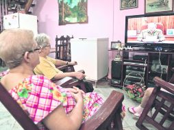 LA HABANA. Cubanos miran en televisión al presidente Raúl Castro mientras da a conocer los acuerdos con Estados Unidos. AFP /