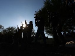 Elementos de la Fuerza Rural accionan sus armas en honor a Manuel Mora, el hijo de Hipólito que fue asesinado en el tiroteo del martes. AFP / STR