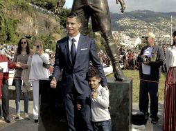 El astro portugués posa con su hijo en el sitio del homenaje. AFP / J. Goulao
