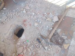 El agujero, de unos 40 centímetros de diámetro, es hecho con un pico que dejan abandonado junto a una lámpara y una soga. EL INFORMADOR /