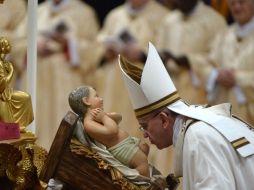 El Papa Francisco besa al bebé Jesús durante la misa de Nochebuena para celebrar el nacimiento de Jesucristo. AP / A. Pizzoli