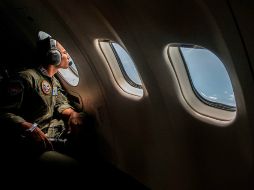 Un militar indonesio observa tras la venta de un avión durante el operativo de rescate de víctimas. AFP / J. Kriswanto