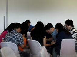 Familiares de los pasajeros del avión desaparecido de AirAsia oran juntos mientras esperan más detalles del accidente. AFP / M. Vatsyayana