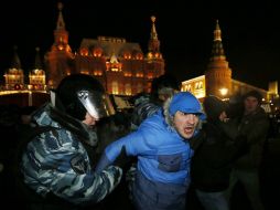 Dos agentes detienen a un simpatizante del líder ruso de la oposición extraparlamentaria Alexéi Navalni. EFE / Y. Kochetkov