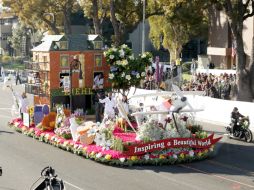 Los carros alegóricos recorren las calles de Pasadena y la gente toma fotografías. AP / T. Williamson