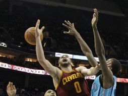 Kevin Love (0) de los Cavaliers de Cleveland  pelea un rebote entre dos jugadores de los Hornets de Charlotte. AP / C. Burton