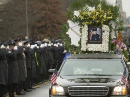 Policías del Departamento de Nueva York, saludan al vehículo que conduce el cortejo fúnebre del fallecido oficial, Wenjian Liu. AP / J. Minchillo