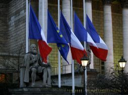 Banderas ondean a media asta en el exterior del Parlamento francés en París, Francia. EFE / Y. Valat