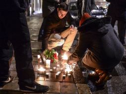 Franceses encienden velas como muestra de respeto por las doce víctimas mortales del atentado terrorista de hoy en París. AP / C. Bresciani