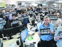 Periodistas de la Agence France Presse guardan un minuto de silencio por las víctimas del semanario francés. AFP /