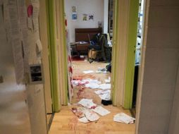 En la imagen se pueden apreciar varios documentos en el piso, manchados con sangre. ESPECIAL / www.lemonde.fr