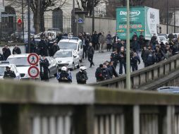 La policía y algunos curiosos permanecen cerca del lugar del tiroteo y la toma de rehenes. AFP / T. Samson