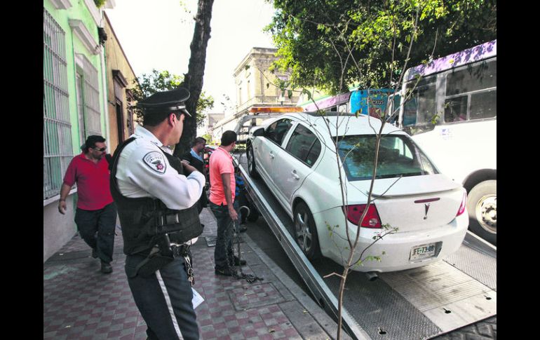 Centro tapatío. Una grúa remolca uno de los vehículos estacionados en zona prohibida, como parte del operativo 'barredora'. EL INFORMADOR / F. Atilano