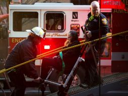 Los bomberos suben a una mujer a un vehículo para recibir asistencia médica. AFP / P. Richards
