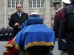 Hollande coloca la medalla sobre los féretros de los tres policías fallecidos, cuyos ataudes portaba una bandera francesa. EFE / F. Mori