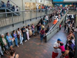 La escasez ha provocado que la gente en Venezuela haga largas filas en supermercados. AFP / F. Parra