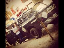 El policía se encontraba sentado en la patrulla mientras besa y abraza a una mujer que se encuentra fuera de la unidad. TWITTER / @informador_JAL