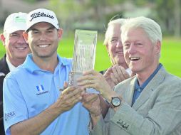 El expresidente de los Estados Unidos, Bill Clinton (derecha), entrega a Bill Haas el trofeo de campeón del Humana Challenge. AP /