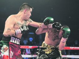 Contundente. Mike Alvarado (derecha) recibe el castigo de Brandon Ríos durante la pelea en el First Bank Center. AFP /