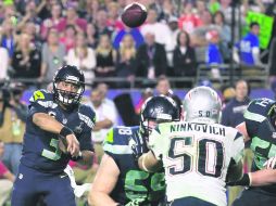 Russell Wilson (izquierda), quarterback de los Halcones Marinos de Seattle, lanza el pase que provocó la intercepción. AFP / R. Carb