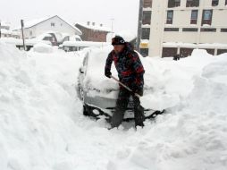 Un hombre remueve nieve de su carro luego de una fuerte tormenta. AFP / ARCHIVO